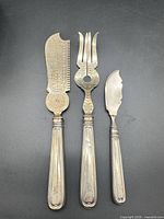 Full view of three sterling serving pieces side by side
