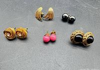 All five pairs of earrings displayed on black background
