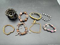 Eight assorted bracelets laid out on black surface
