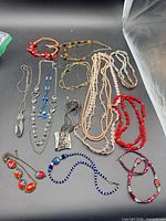 Full group of necklaces and bracelets laid out on black background