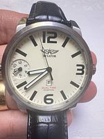 Front view of Aviator watch showing dial, hands, numerals, dual-time sub-dial and date window