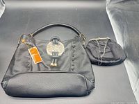 Front view of Michael Kors handbag and black satin purse