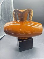 Full view of brown ceramic vase on stand