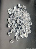 pile of clear acrylic faceted crystals on black surface