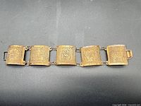 Full view of bracelet showing six engraved panels and clasp