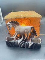 Full view of lamp showing horse base, twin receptacles, illuminated shade