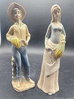 Front view of both porcelain farmer figurines