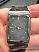 Front view of Seiko Quartz rectangular wristwatch showing dial, markers, hands and bracelet