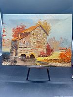 Full view of signed oil painting on easel