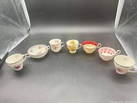 Group shot of six teacups and one soup bowl arranged in semicircle