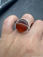 Ring on finger showing full view of amber cabochon and bezel setting