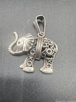 Front view of elephant pendant showing design and bail