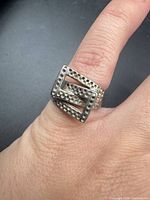 Ring on finger showing geometric double square face