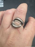 Ring on finger showing abstract oval design