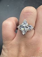 Top view of sterling silver ring with marquise and round CZ stones on finger