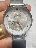Front view of watch showing dial, subdials, hands, brand name and overall condition