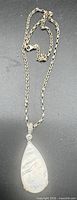 Full view of silver chain and teardrop pendant