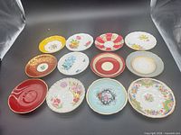 All twelve bone china saucers arranged in two rows showing varied designs