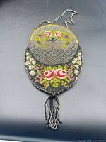 Full view of beaded purse showing floral pattern, frame, chain, and tassel
