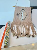 Full view of macramé wall hanging with ruler for scale