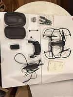 Full layout showing drone, controller, battery, charger, prop guards, spare props, case, manuals