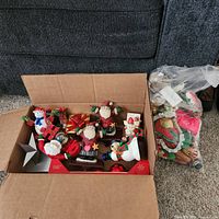 Overview of open box with metal shelf sitters, star topper, bag of fabric ornaments