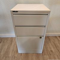 Front view of Bisley white three-drawer metal filing cabinet