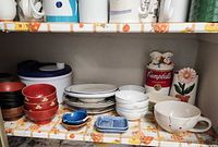 Shelf with lacquer bowls, plates, rice bowls, Campbell’s canister, mug, plastic canister