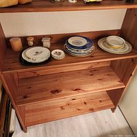 Shelf with plates, votives, trinket box visible