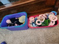 Two plastic bins showing assorted yarn skeins and crocheted pieces