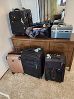 Group view of four rolling suitcases, duffel bag and train case