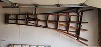 Full view of both wooden ladders mounted horizontally on wall