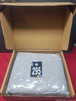 Sealed light grey sheet set inside opened shipping box