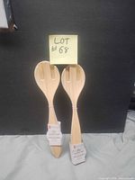 Two bamboo fibre salad utensils with tags displayed side by side