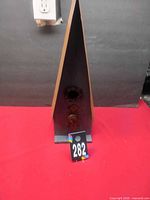 Front view of wooden blue birdhouse with metal roof and entry hole