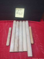 All seven wooden rolling pins on red surface
