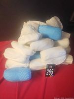 Stacked rolls of blue and white disposable shoe covers with lot tag visible