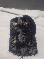 Top view showing zipper closure, ruffled sides, velvet handles, gold-tone joints