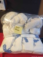 Front view of clear bag filled with folded white lap sponges showing blue radiopaque stripes and sticky note with lot number