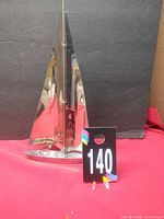 Front view of polished metal sailboat sculpture with lot number