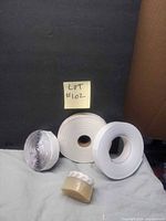 Overall view of four tape rolls on fabric backdrop with lot number note