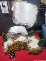 Front view of both foam mountain pieces showing snow finish, moss, trees