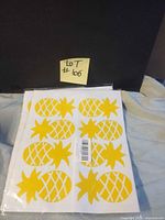 Two sealed packs of yellow pineapple stickers on white sheets