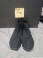 Front and side view of the black Sanuk shoes