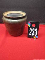 Front view of glazed stoneware vase next to lot number