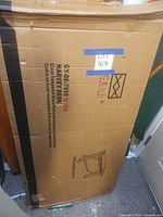 Box showing brand and model of desk containing glass panels