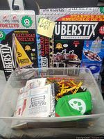 Bin with assorted Uberstix pieces, manuals, green bag; sailboat and starter set boxes behind