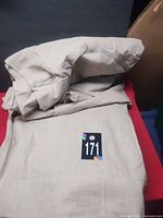 Folded beige curtain panels showing fabric texture