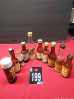 Group shot of all ten vintage mini liquor bottles on red surface