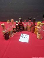 Front view of all ten miniature liquor bottles standing on red surface